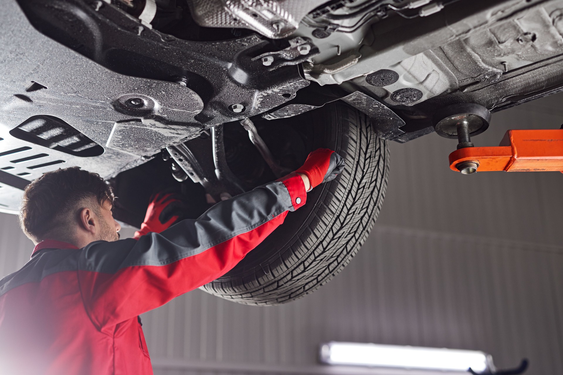 Male mechanic fixing car wheel